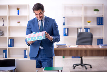 Young male employee celebrating birthday at workplace