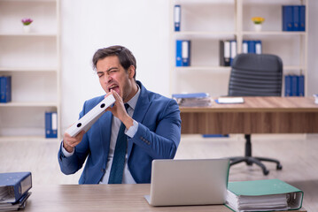 Young male employee eating pizza at workplace