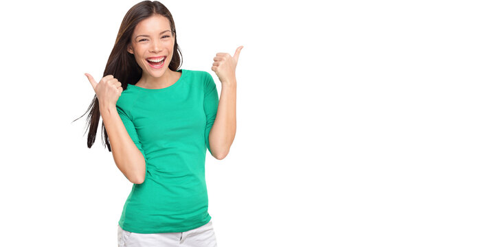 Thumbs up happy excited woman isolated on white background in green t-shirt. Cheerful joyful and elated girl looking at camera. Multiracial Asian Caucasian girl in her twenties.
