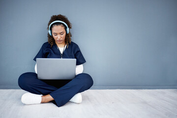 Woman, laptop and headphones of hospital music, podcast or radio in woman study research or mockup nurse learning. Doctor, technology and medical student listening to healthcare audio for focus help