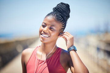 Fitness, black woman and happy runner with earphones for training exercise outdoor. Face, smile and female athlete listening to music for sports motivation, healthy goals and audio of running workout