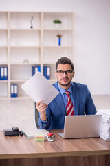 Young male employee unhappy with excessive work in the office