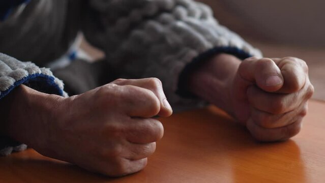 frustrated angry elderly man hits the table with his fists, an angry man reacts with a blow with his fists to the loss and grief while being at home.concept disappointment, aggression