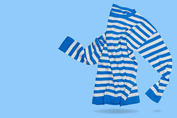 Sweater with blue and white stripes, as if walking, concept on a light blue background