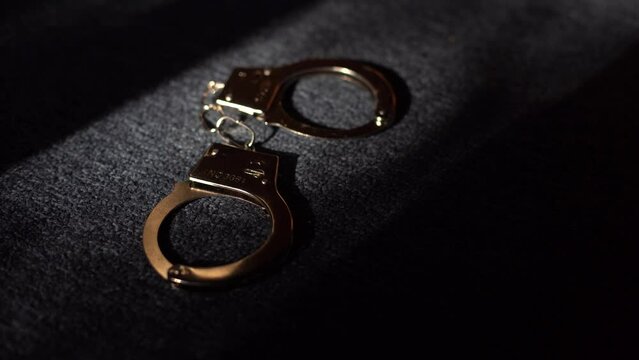 handcuffs on a gray background. Concept: legal problems, criminal, offenses, white collar, convict, detainee, imprisonment
