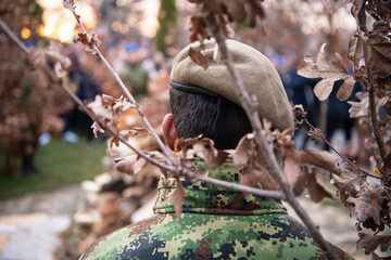 Serbian soldier carries dried oak branches for a ceremonial burning - the Yule log symbol for the Orthodox Christmas Eve in front of St. Sava church on January 6, 2023 in Belgrade, Serbia
