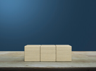 Three block cubes on wooden table over blue wall