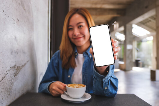 Mockup image of a beautiful woman showing a mobile phone with blank white screen