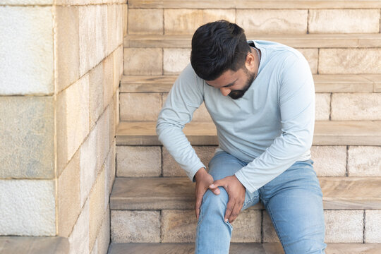 South Asian man falling down from stair, hurting his leg and knee joint