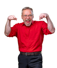 funny senior man showing the muscles with open mouth smiling cheerfully over yellow background