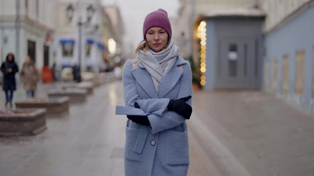 casual dressed adult woman walking alone on city street in cold day of snowless winter
