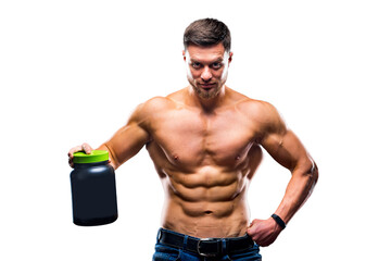 Male athlete bodybuilder with a naked torso holds a jar of sports nutrition in his hands and poses...
