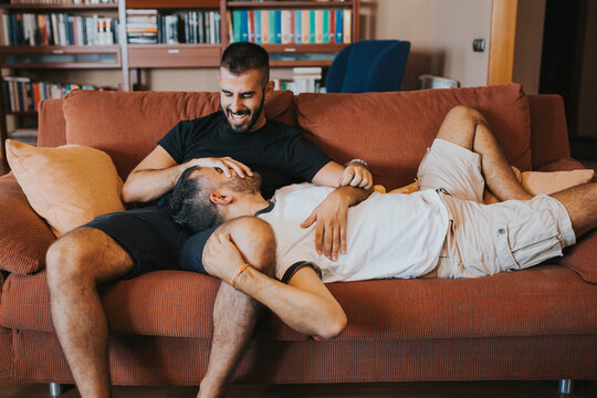 gay couple having fun and laughing on the couch