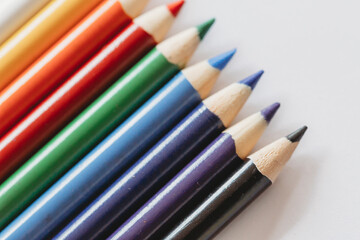 Multi-colored coloring pencils on white background