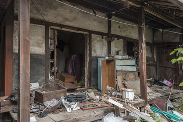 Ubex, abandoned doorway of a traditional South-Korean house, the walls, door and windows are broken, there are remains on the floor, it is messy, dirty and dusty