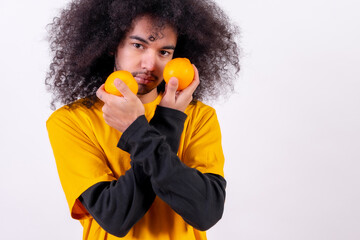 Portrait with orange fruit. Young boy with afro hair on white background