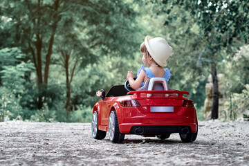 A girl riding a toy car