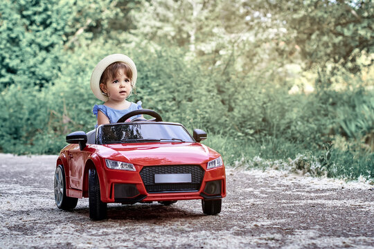 A girl riding a toy car