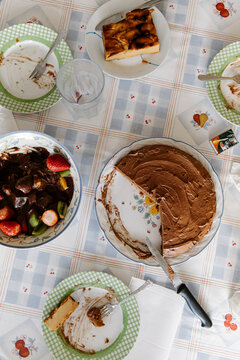 Chocolate birthday cake on table with dirty plates after celebration