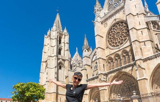 woman with open arms in front of the cathedral of Leon in Spain