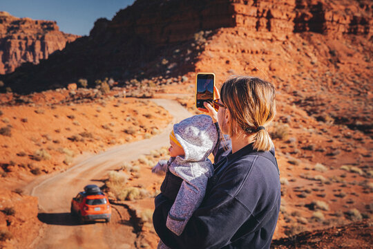 A woman with a child is taking pictures in Valley of the Gods, Utah