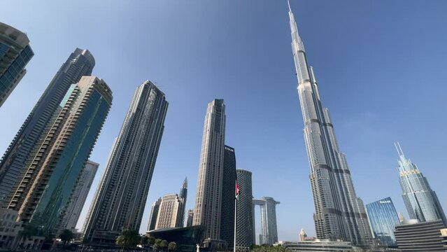 Shot from the ground with a Burj Khalifa skyscraper tower wide angle lens. The tallest building in the world. Filmed during the day with fountain in front. UAE