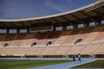 Obraz premium Girls running on a blue sports track
