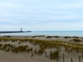 Fototapeta na wymiar January 2023, Dunkerque - Winter walk on the beach of Dunkerque - View on the lighthouse 