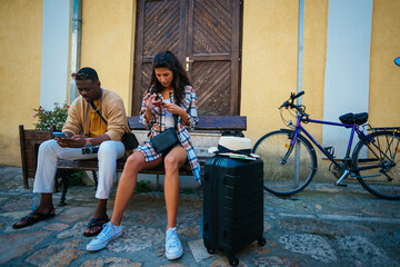 Fototapeta na wymiar Two tired tourists sitting on a bench