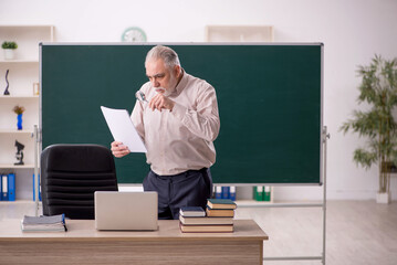 Old male teacher in the classroom