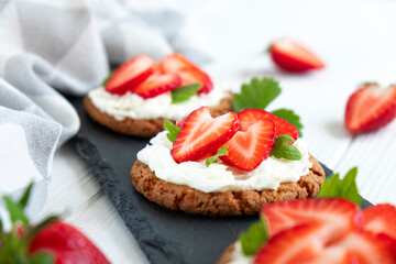 Healthy sandwich with strawberry and cream cheese on slate board. Tasty breakfast. Clean eating, diet or easy recipe of vegetarian sandwich for vegan menu.