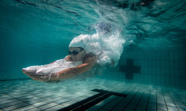 Underwater photo of a female swimmer diving into an olympic standard swimming pool