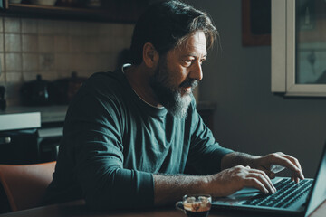Mature male workaholic involved in work overtime, type report letter on laptop, search data at web. Ambitious young man in smart working develop career spend free time on computer at home alone indoor