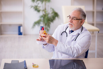 Old male doctor cardiologist working in the clinic