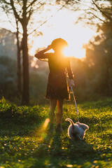 Chica joven con cachorro posando al atardecer en un bosque