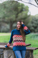 Chica joven delgada posando al atardecer con ropa de invierno y sombrero