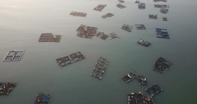 Drone shot of fishing cages floating in calm sea