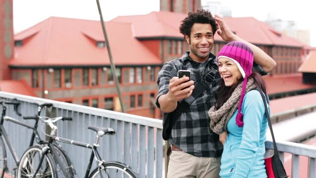 Medium shot couple looking at cellphone while in embrace