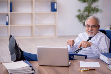 Fototapeta premium Old male employee working in the office