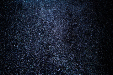 Organic dust particles floating on a colorful light beam on black background. Glittering sparkling flickering overlay. High quality photo