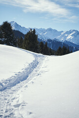 Mountain narrow path covered with snow near the mountain range.