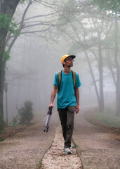 Photographer in the woods on a foggy morning