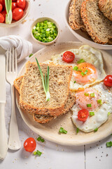 American breakfast with fried eggs, chive and bread.