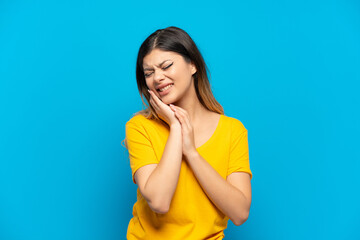 Young Russian girl isolated on blue background with toothache