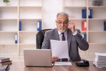 Old male employee working in the office