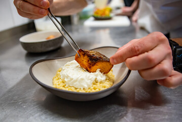 chef hand cooking grilled salmon fish fillet with creamy ptitim