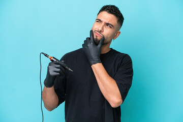 Tattooist Arab man isolated on blue background having doubts