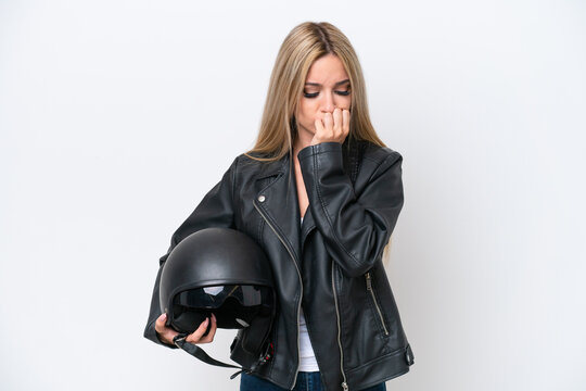 Pretty blonde woman with a motorcycle helmet isolated on white background having doubts