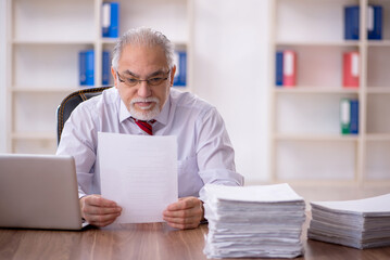 Fototapeta premium Old male employee and too much work in the office