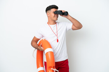 Young handsome man isolated on white background with lifeguard equipment and with binoculars - obrazy, fototapety, plakaty